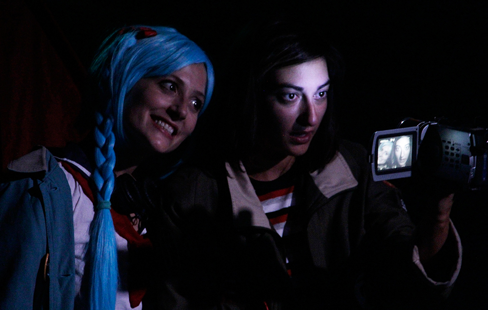 dos chicas otakus filmando a la luz de una linterna